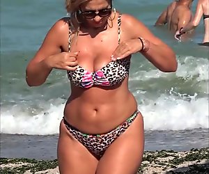 Candid big ass milf in tiny bikini at the beach